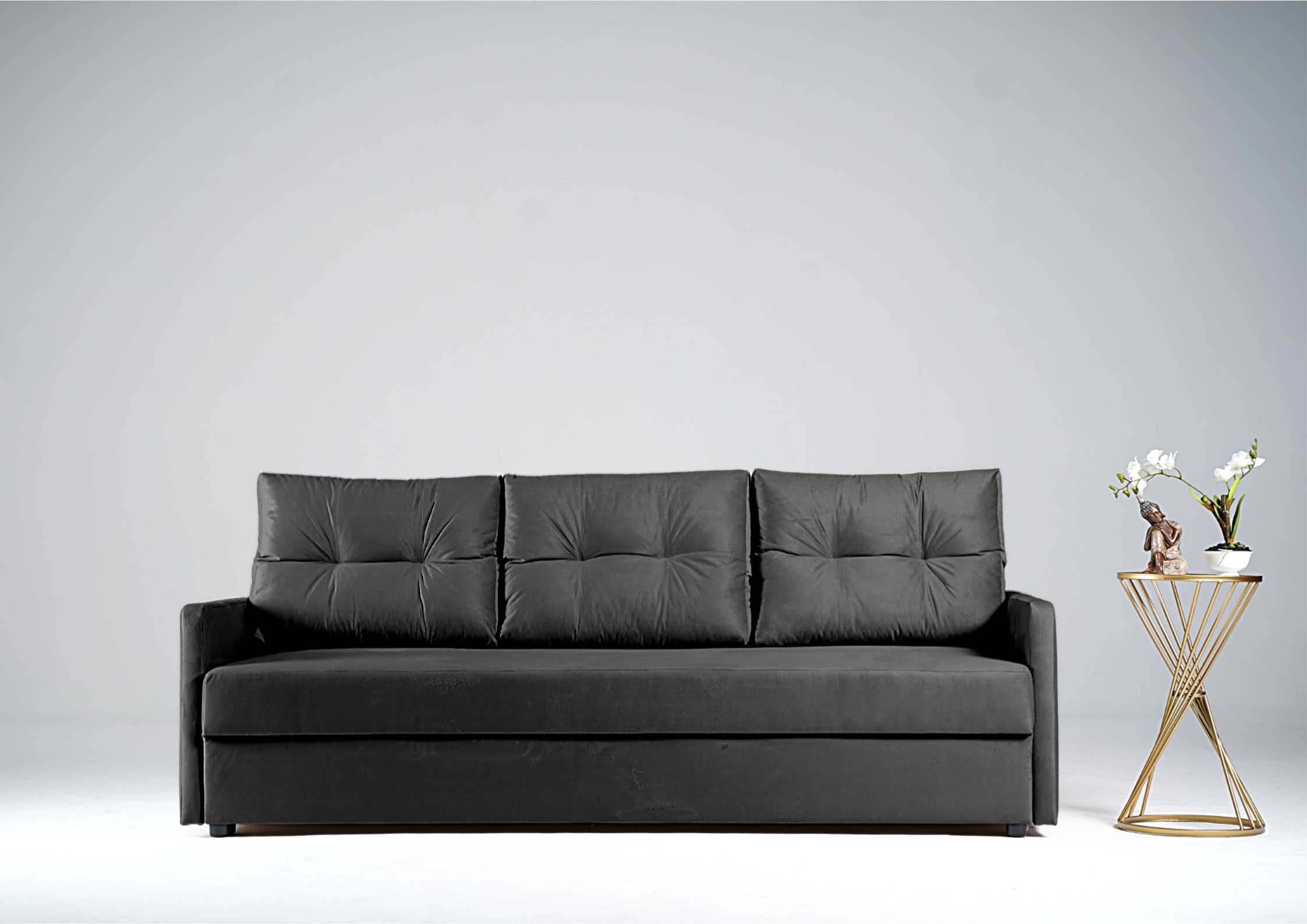 Grafitowa sofa z pikowanymi poduszkami